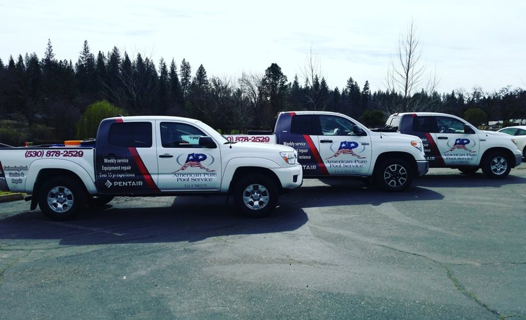 American Pure Pool Service branded trucks parked in a row